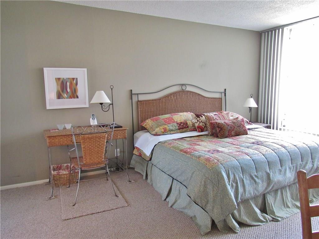 2661 South Course Drive, Unit 404 Pompano Beach, FL 33069 - Photo 8 of 16 a bedroom with a bed and a chair