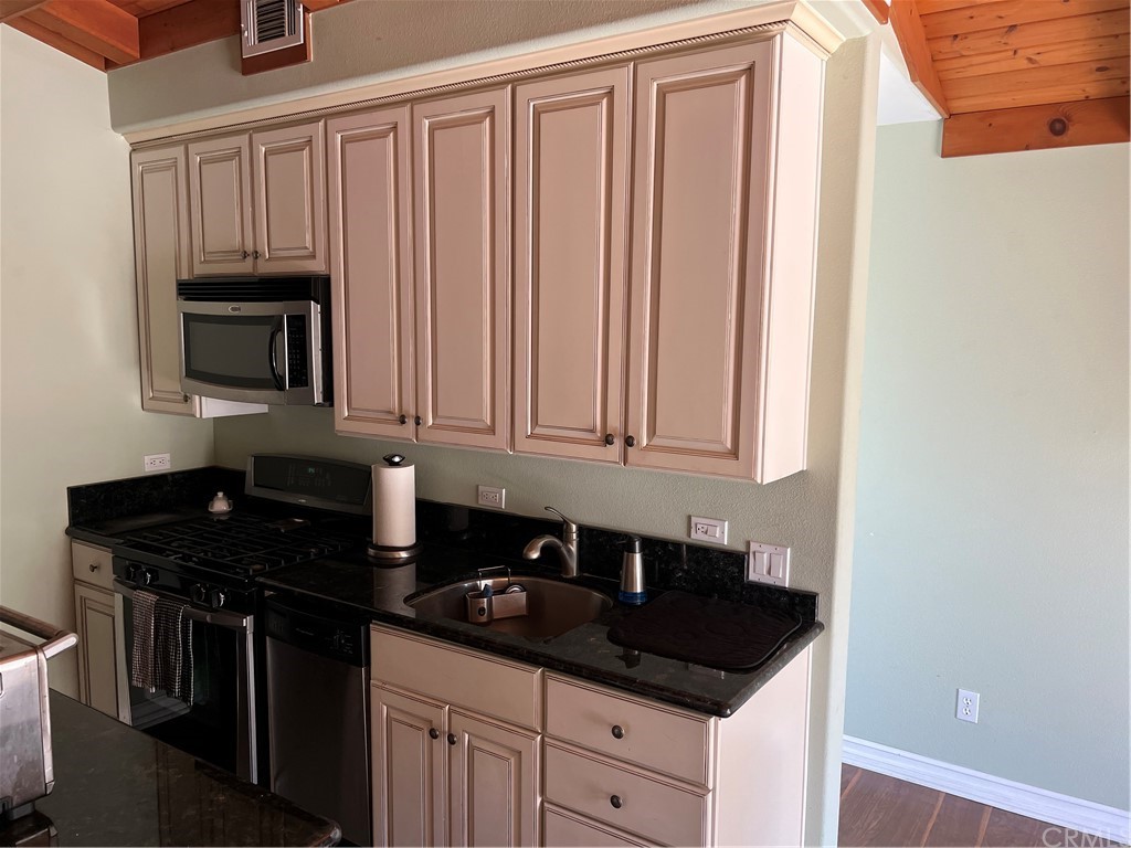 2378 Cornell Drive Costa Mesa, CA 92626 - Photo 35 of 40 a kitchen with granite countertop white cabinets and black appliances
