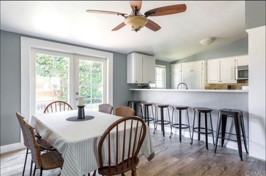2378 Cornell Drive Costa Mesa, CA 92626 - Photo 7 of 40 a kitchen with a dining table chairs and white cabinets
