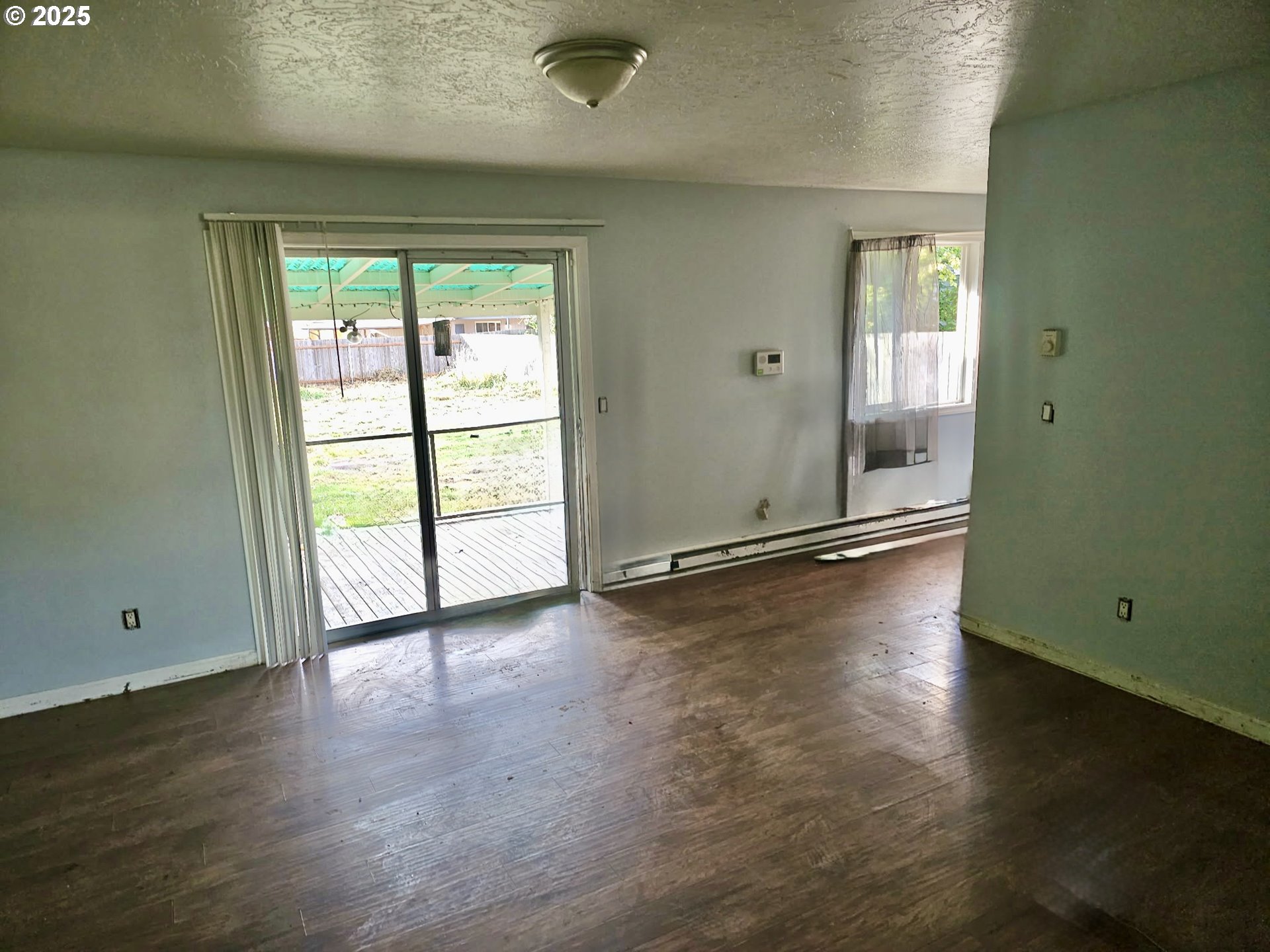 2231 46th Avenue Longview, WA 98632 - Photo 5 of 5 an empty room with wooden floor and windows with curtains