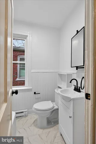 a bathroom with a toilet a sink and mirror