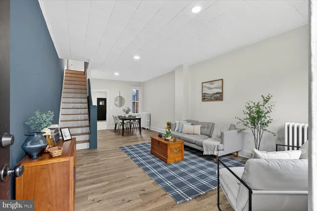 a living room with furniture and wooden floor