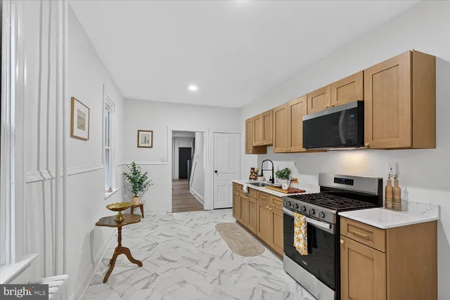 a kitchen with stainless steel appliances kitchen island granite countertop a stove a sink and a microwave