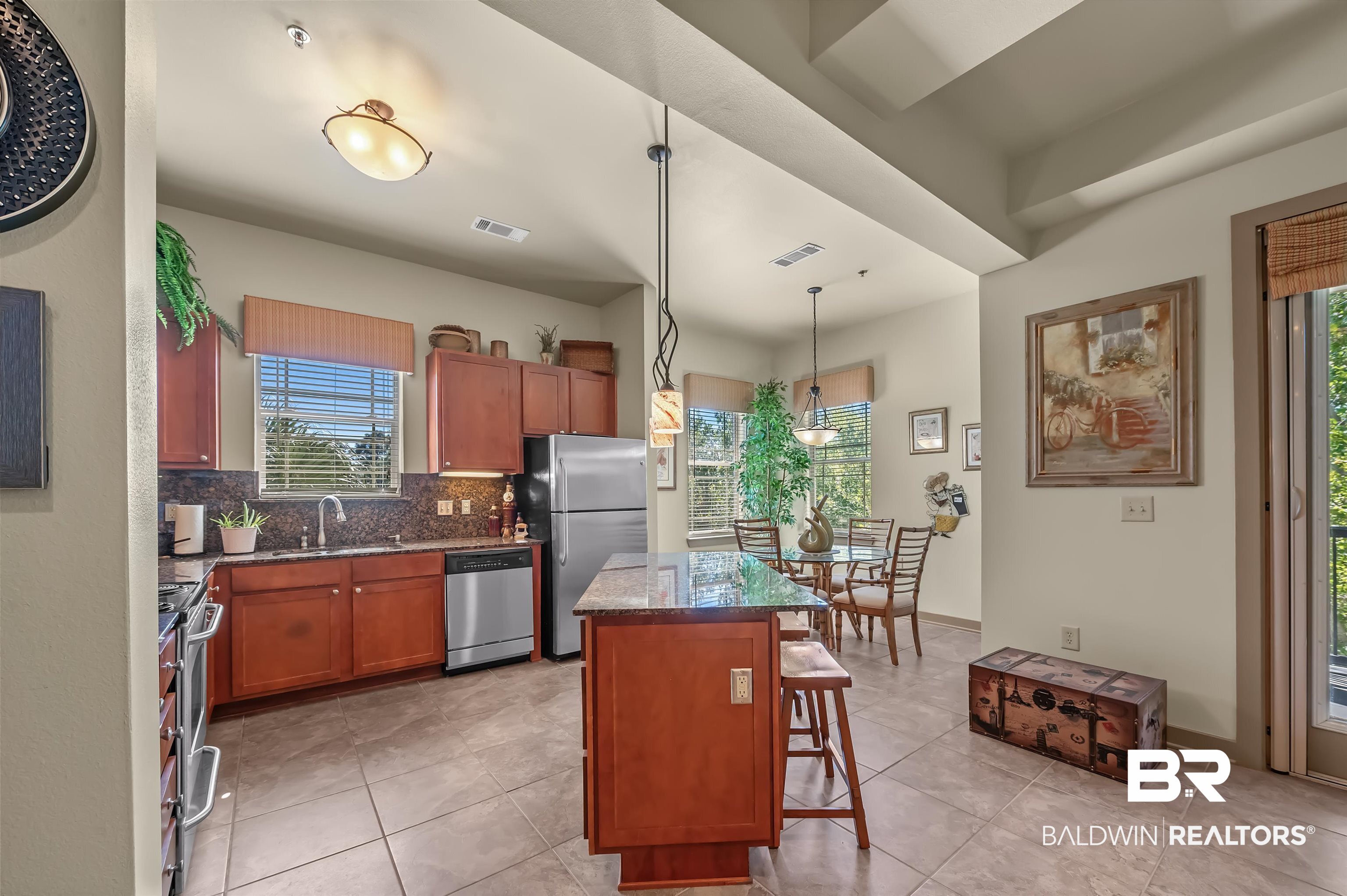 1430 Regency Road, Unit A301 Gulf Shores, AL 36542 - Photo 12 of 47 Kitchen featuring decorative backsplash, a breakfast bar, stainless steel appliances, pendant lighting, and a center island