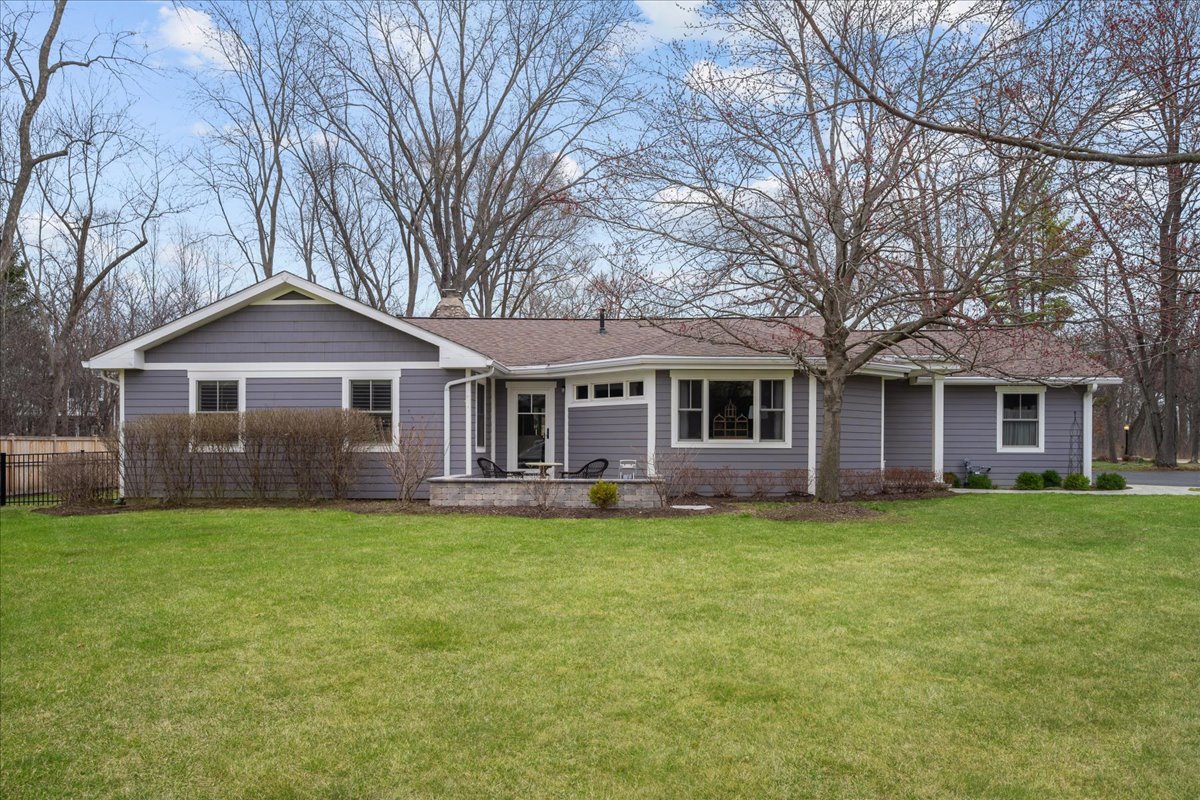 a front view of a house with a garden and trees
