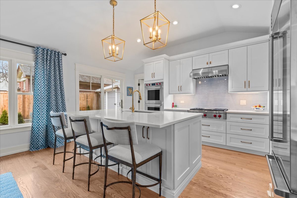 140 West Old Elm Road Lake Forest, IL 60045 - Photo 12 of 38 a kitchen with stainless steel appliances granite countertop a stove a sink dishwasher a dining table and chairs with wooden floor
