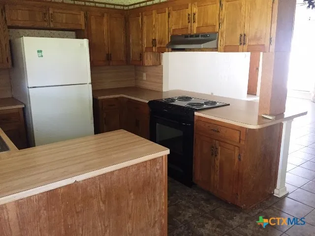 a kitchen with a wooden floor and a stove top oven