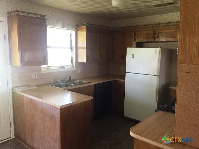 a kitchen with a refrigerator and a sink