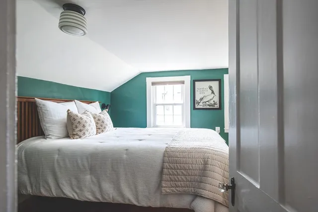 a bedroom with a balcony a bed and window