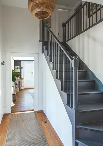 a view of staircase and living room with wooden floor and a rug