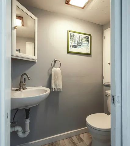 a bathroom with a toilet sink and mirror