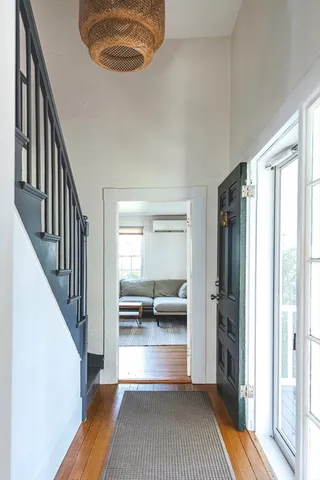 a view of a hallway with wooden floor and staircase