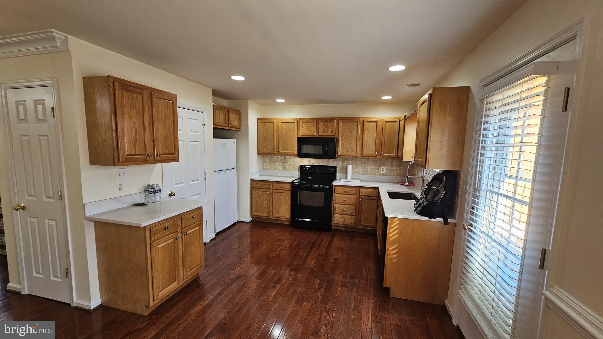 201 Eastside Lane Winchester, VA 22602 - Photo 11 of 21 a kitchen with a refrigerator a sink and wooden cabinets