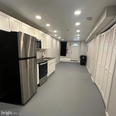 a view of kitchen with stainless steel appliances refrigerator oven and cabinets