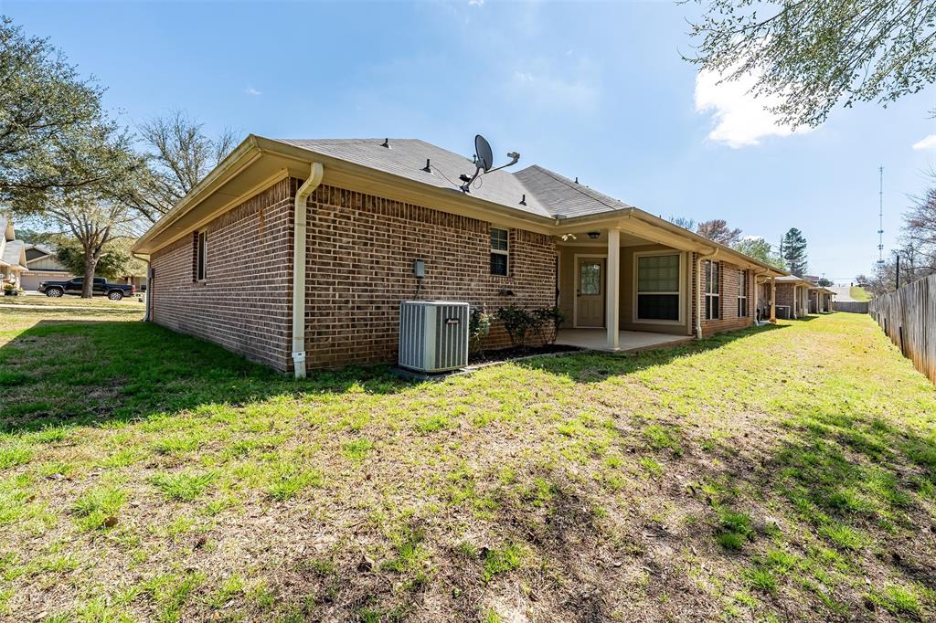 421 West Cumberland Road, Unit 205 Tyler, TX 75703 - Photo 23 of 24 a view of a house with a yard and garage
