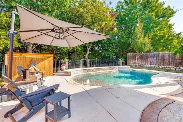 a view of backyard with table and chairs under an umbrella
