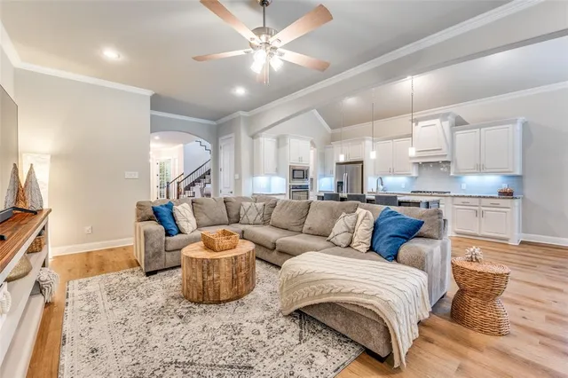 a living room with furniture and a view of kitchen