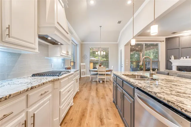 a large kitchen with granite countertop lots of counter top space and stainless steel appliances