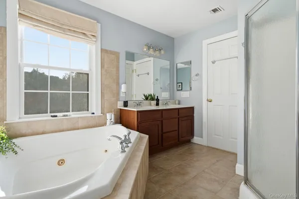 a bathroom with a tub sink and mirror