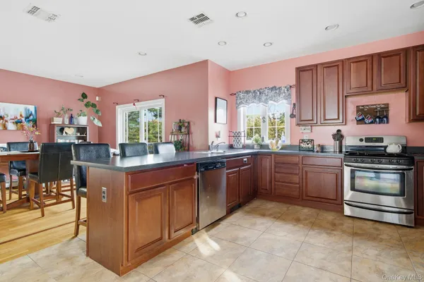 a kitchen with stainless steel appliances granite countertop a stove top oven a sink dishwasher and cabinets with wooden floor