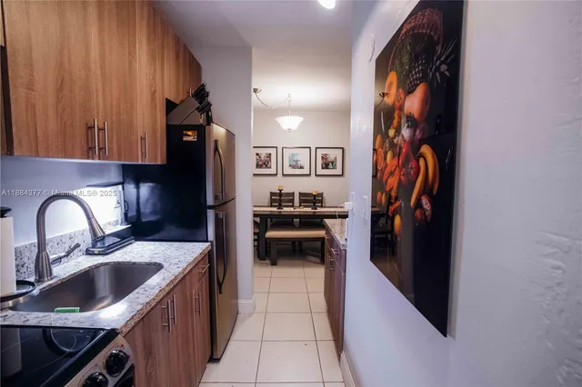 a kitchen with stainless steel appliances granite countertop a refrigerator and a sink