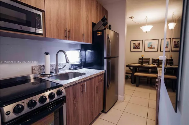 a kitchen with stainless steel appliances granite countertop a stove refrigerator and microwave
