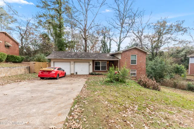 a view of a house with a yard and garage