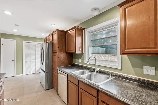 a kitchen with granite countertop a sink and a refrigerator