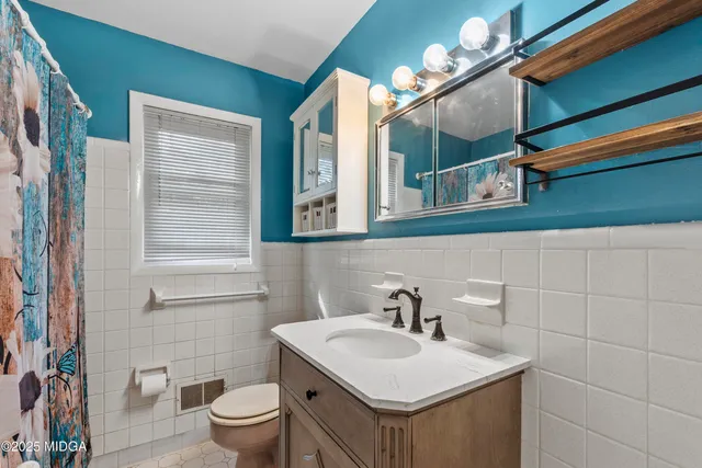 a bathroom with a toilet sink and mirror