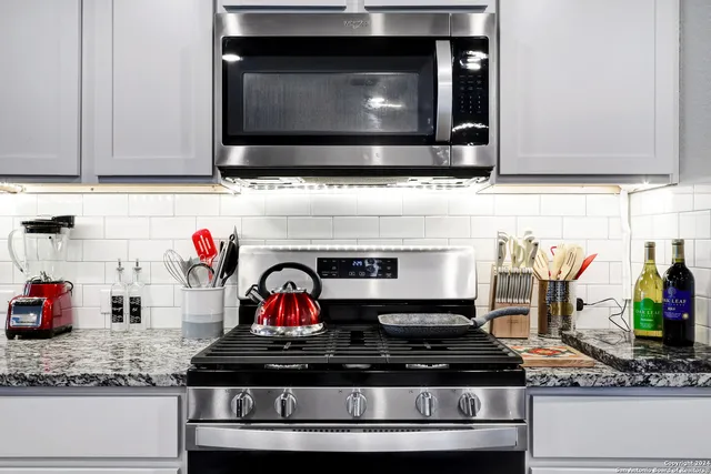 a kitchen with stainless steel appliances granite countertop a stove and a microwave