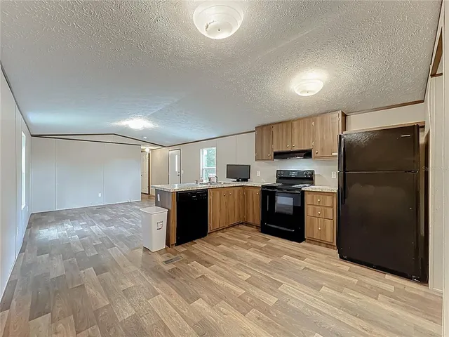 a kitchen with a refrigerator and a stove top oven