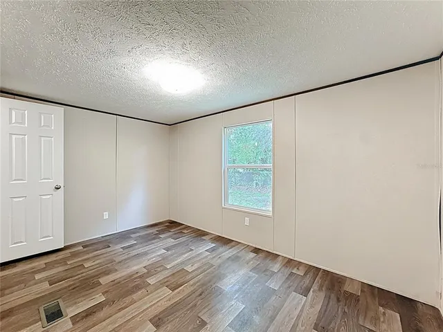 a view of a big room with wooden floor and windows