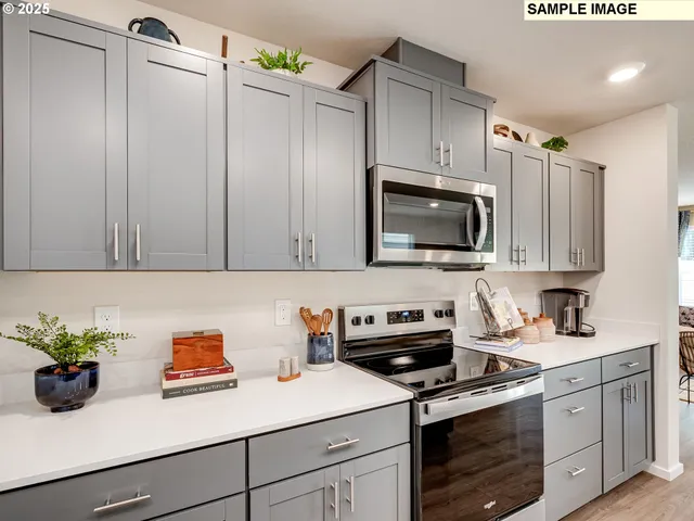 a kitchen with stainless steel appliances a stove a sink cabinets and a microwave