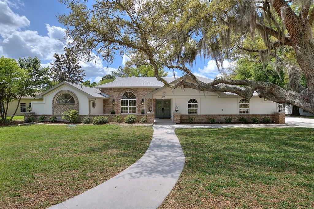 419 Silas Court Spring Hill, FL 34609 - Photo 1 of 56 a front view of a house with garden