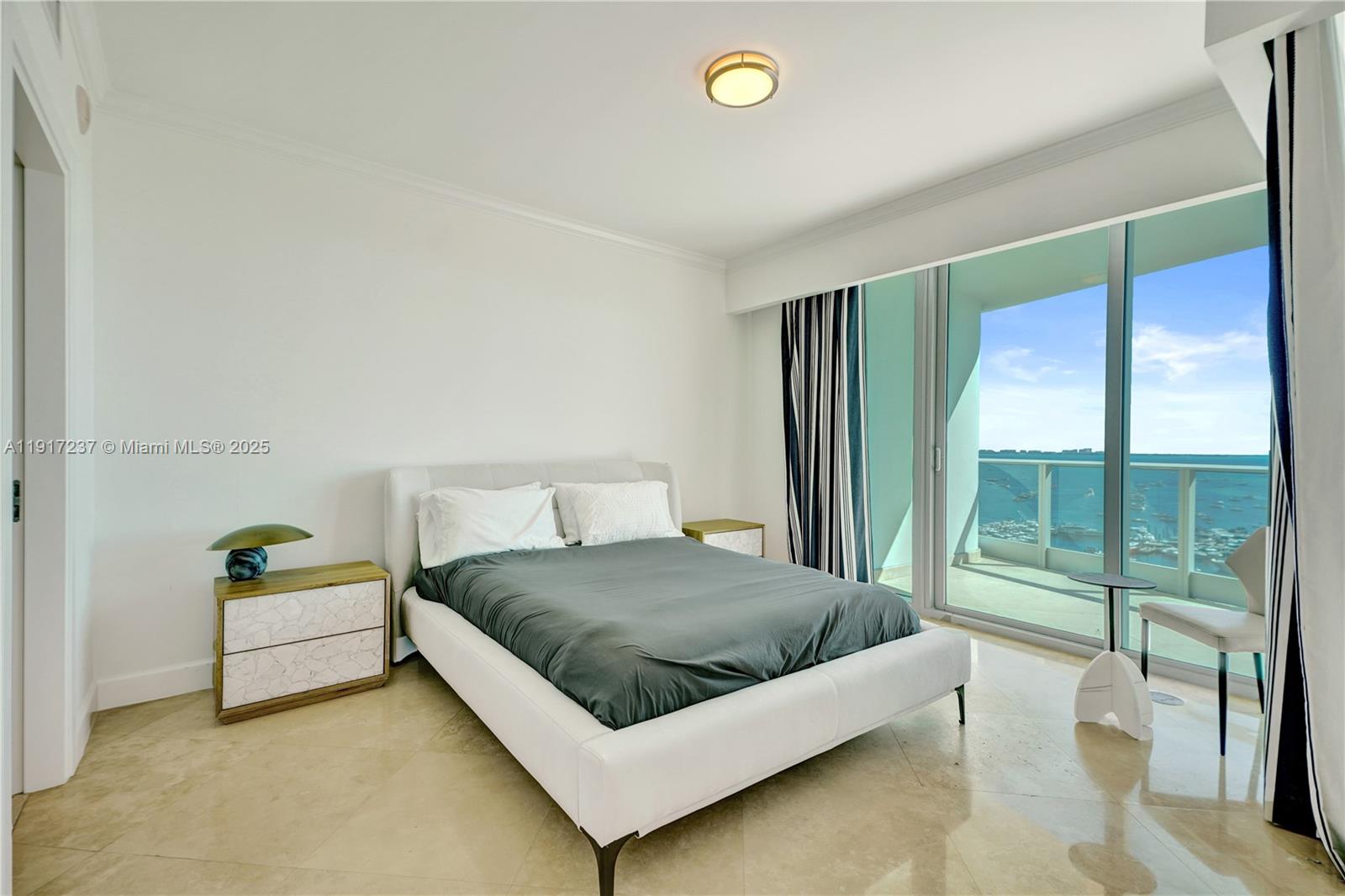 2627 South Bayshore Drive, Unit 1806 Miami, FL 33133 - Photo 21 of 33 a bedroom with a bed and large window
