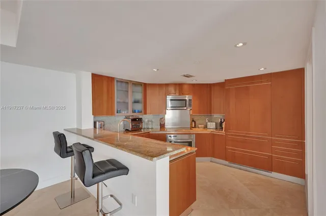 a kitchen with a dining table chairs and white cabinets