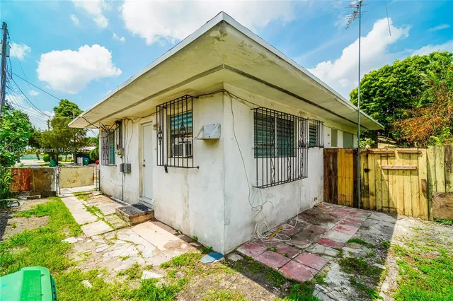 a view of a house with a small yard plants and large tree