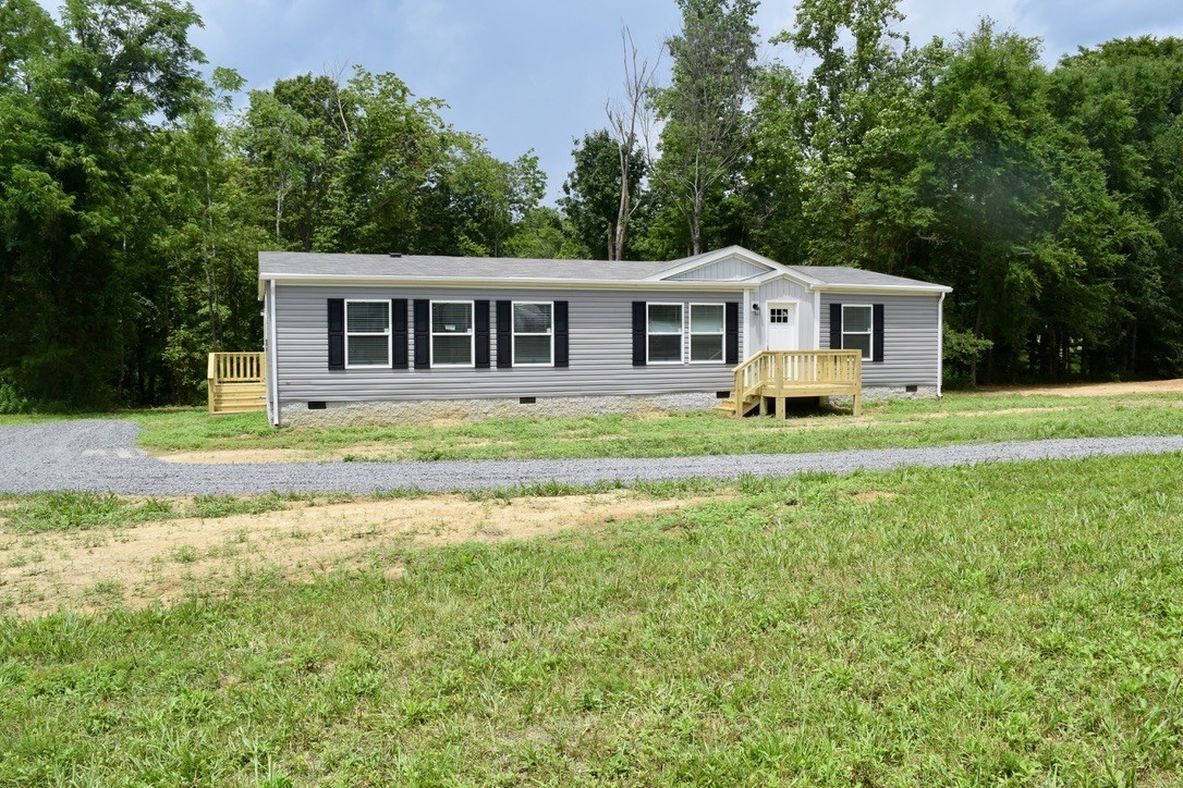 2166 Shrum Cemetery Road Westmoreland, TN 37186 - Photo 2 of 32 a front view of a house with a garden