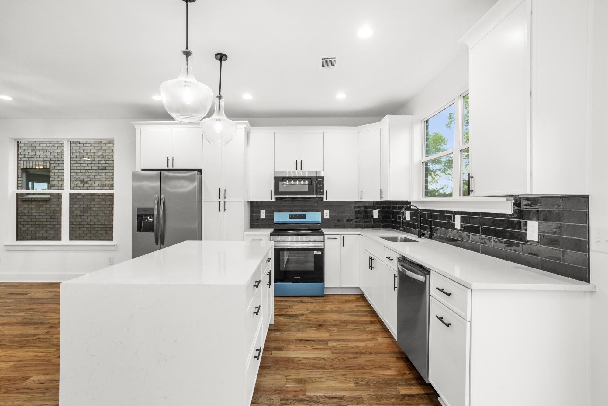 656 Chambers Street, Unit 140 Gallatin, TN 37066 - Photo 5 of 40 a kitchen with stainless steel appliances kitchen island granite countertop a refrigerator a sink dishwasher a stove and white cabinets with wooden floor