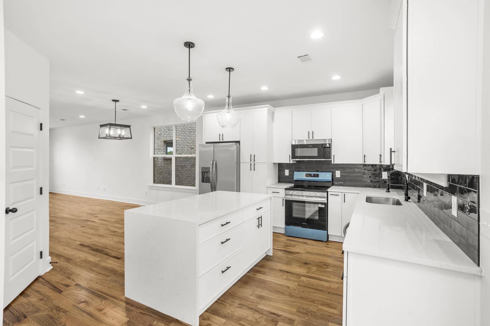 656 Chambers Street, Unit 140 Gallatin, TN 37066 - Photo 6 of 40 a large kitchen with stainless steel appliances kitchen island granite countertop a stove and a sink