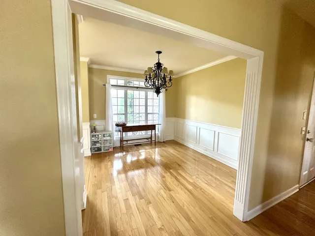 a view of an entryway with wooden floor and a livingroom