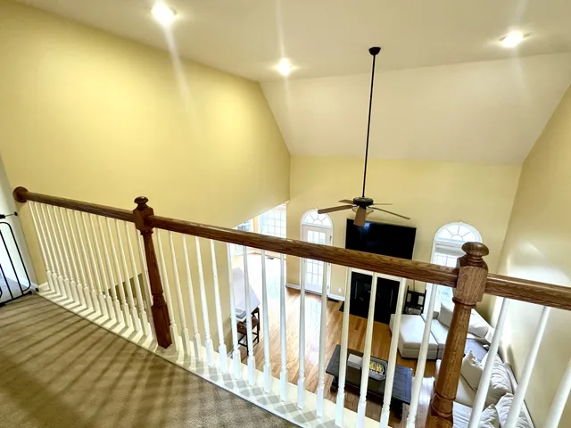 a kitchen with stainless steel appliances wooden floors wooden cabinets a stove a sink and a refrigerator