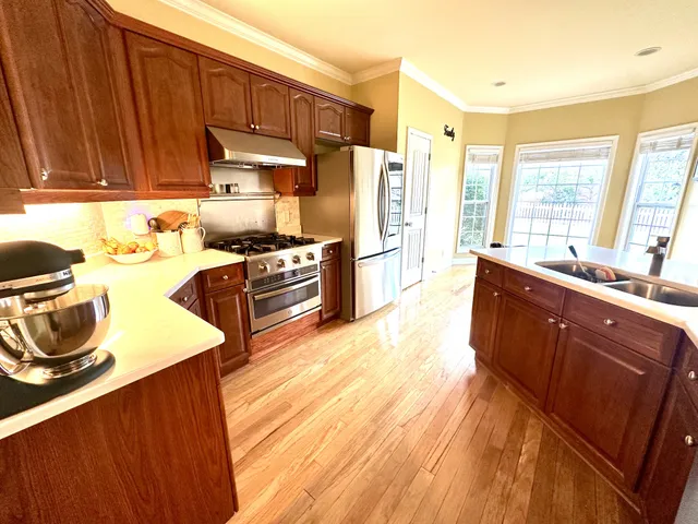 a dining hall with granite countertop a refrigerator and wooden floor