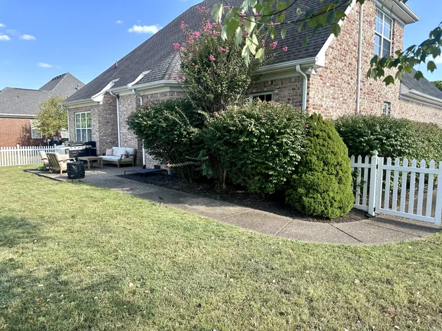 a view of a house with backyard and sitting area