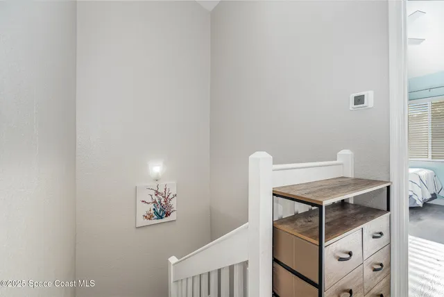 a bed sitting in a spacious bedroom next to a window