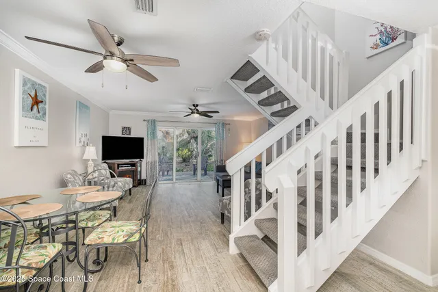 a dining room with wooden floor a chandelier a wooden table and chairs