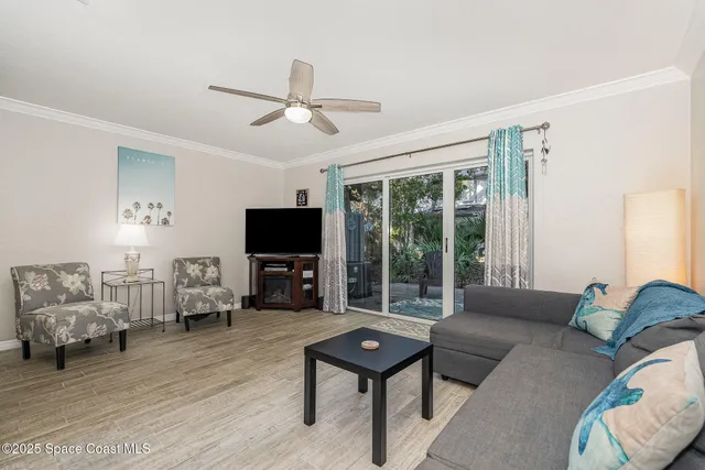 a living room with furniture a flat screen tv and a large window