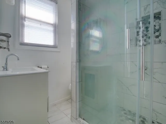 a bathroom with a sink a shower and a mirror