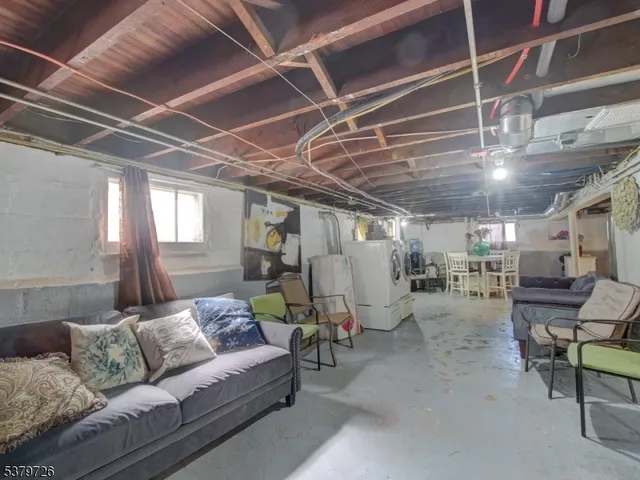 a media room with lots of furniture and a chandelier