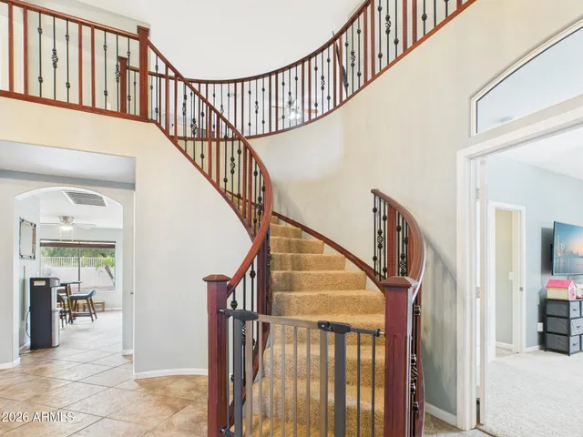 a view of staircase with lots of frames on wall and a large window